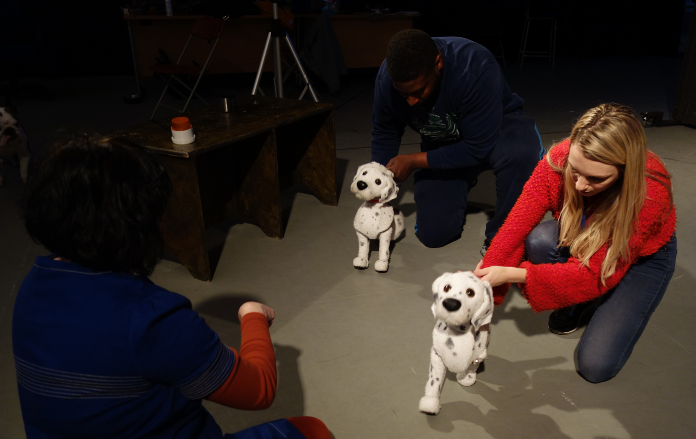 the dog is a puppet ( a dalmation) trying to get to know Bubble, in picture is women in red holding puppet.