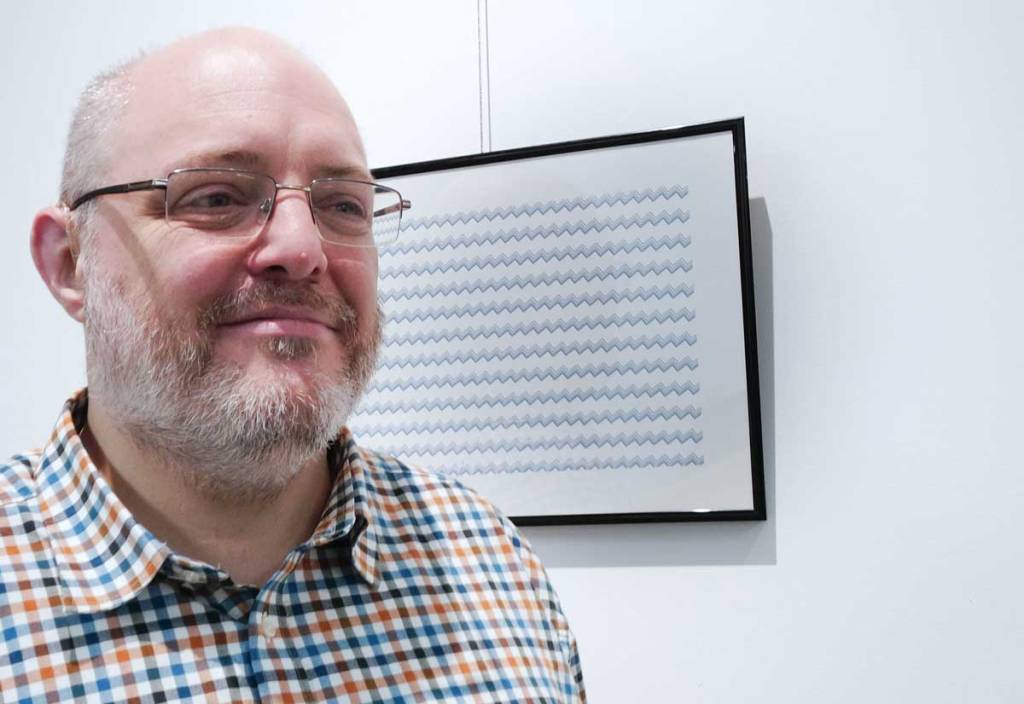 Man in pattern shirt Stands in front of picture